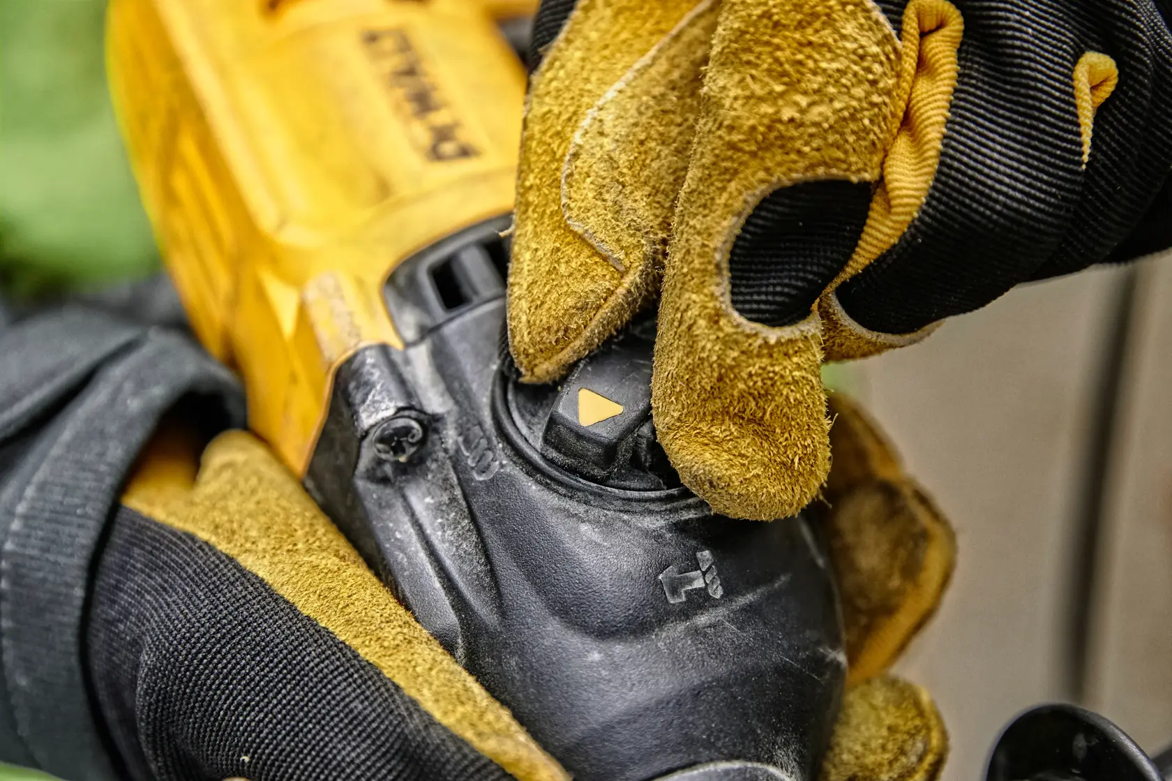 Nahaufnahme einer behandschuhte Hand, die den Moduswahlschalter an einem DEWALT Elektrowerkzeug einstellt, mit gelbem und schwarzem Werkzeuggehäuse und Kontrollrad.
