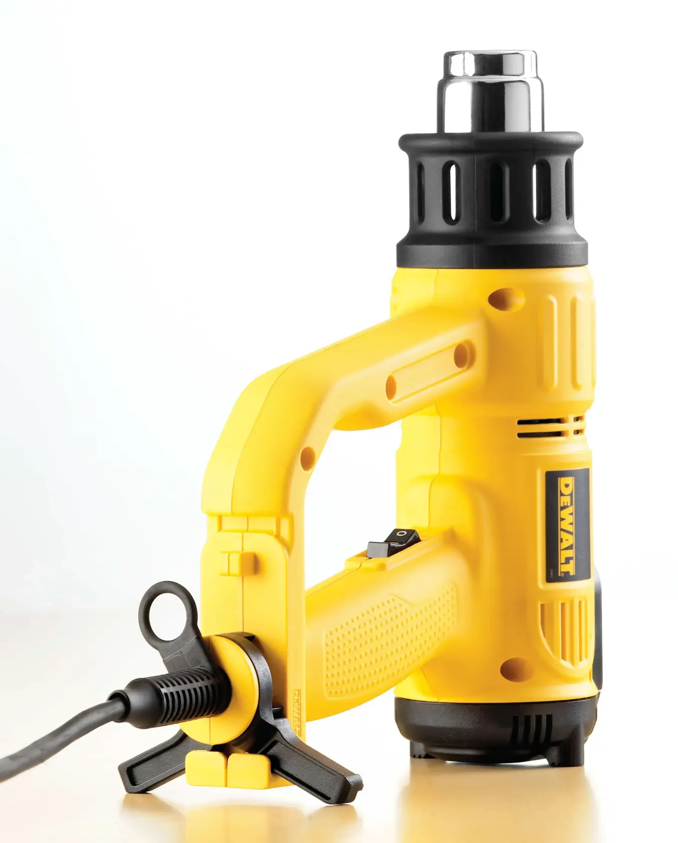 DEWALT D26414 gelbe Heißluftpistole mit schwarzer Düse und Kabel auf heller Oberfläche.