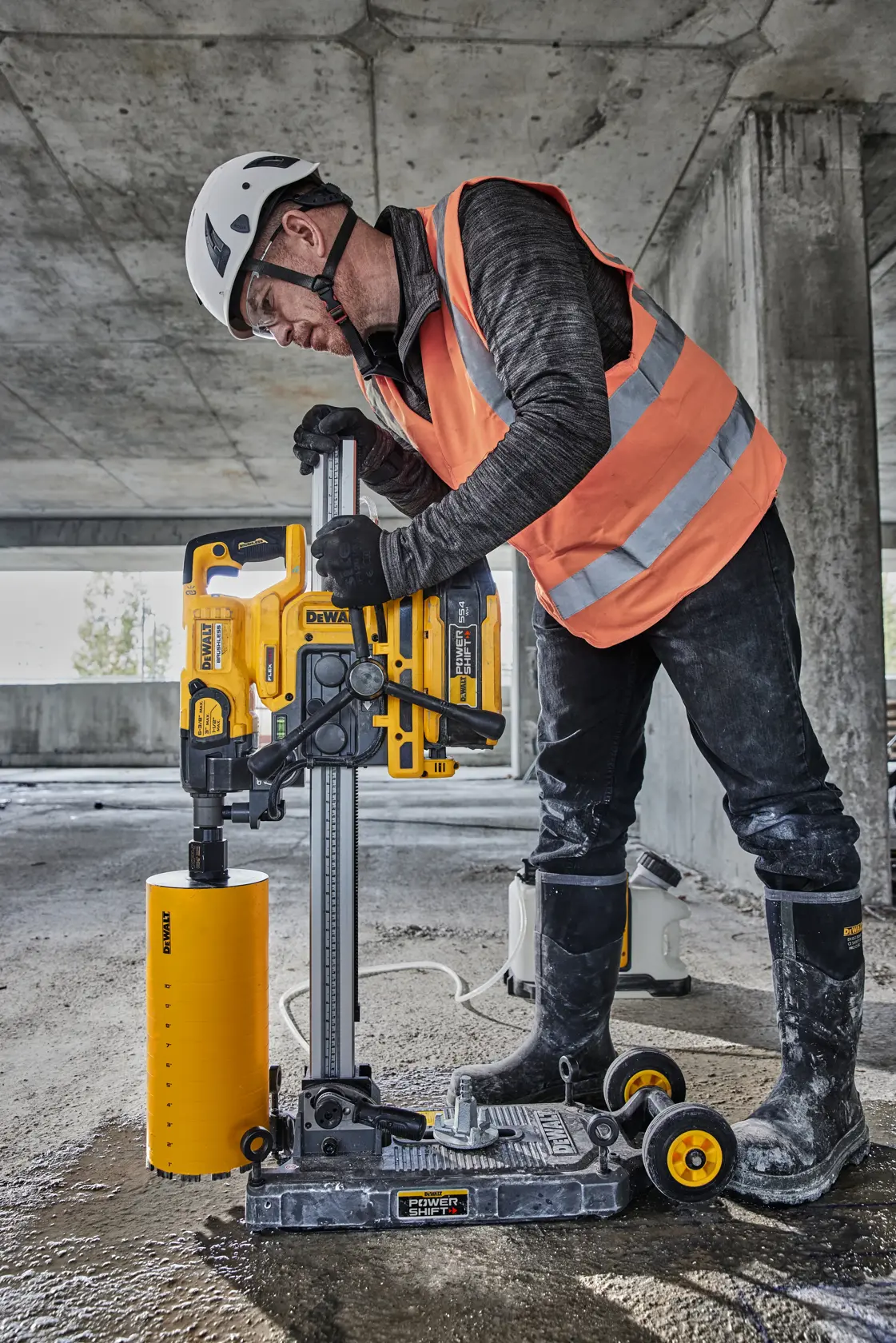 Trabajador usa taladro DEWALT DCPS151 en obra. Lleva equipo de seguridad y utiliza la herramienta amarilla.