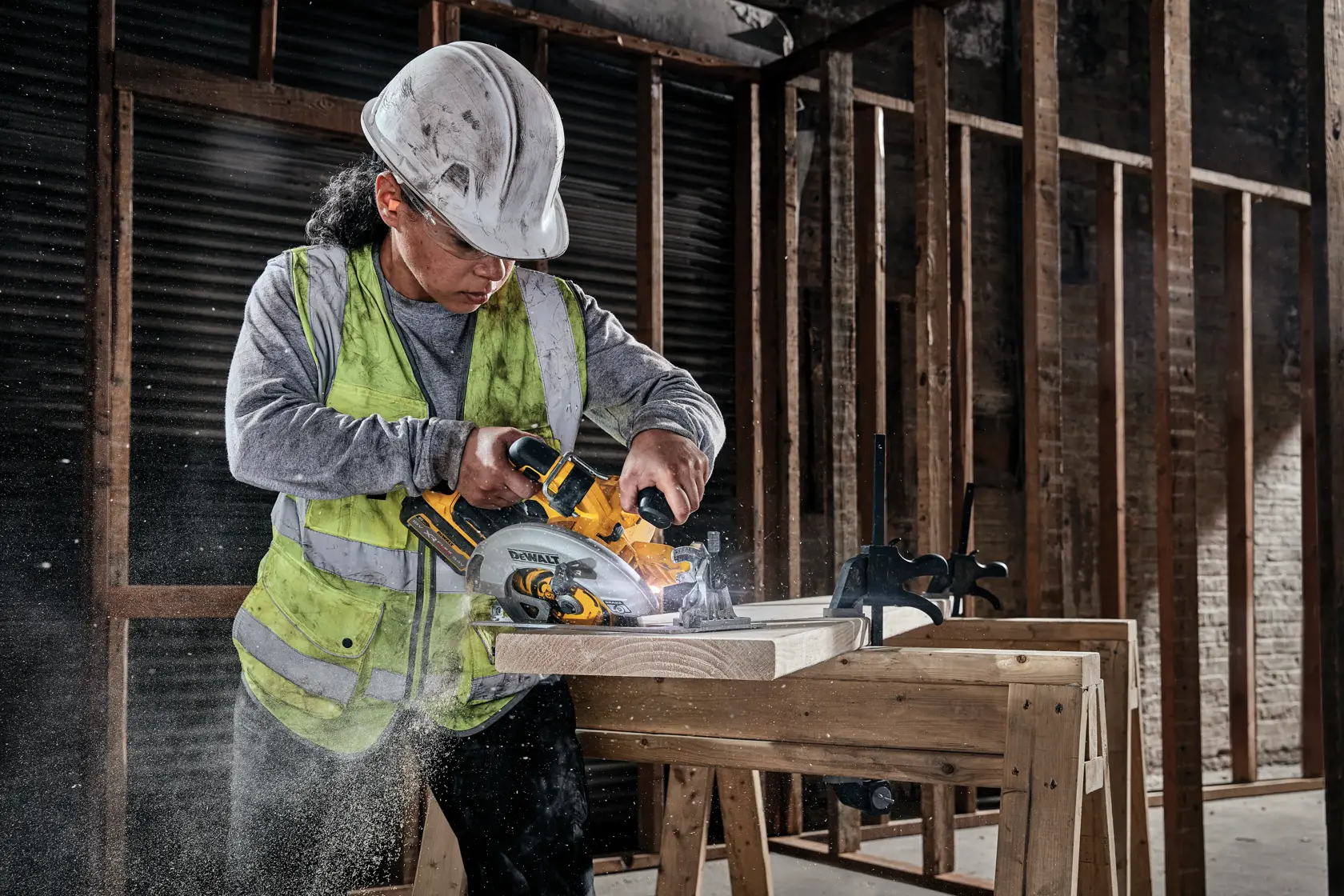 Trabajador corta madera con la sierra circular DEWALT DCS573NT en obra.