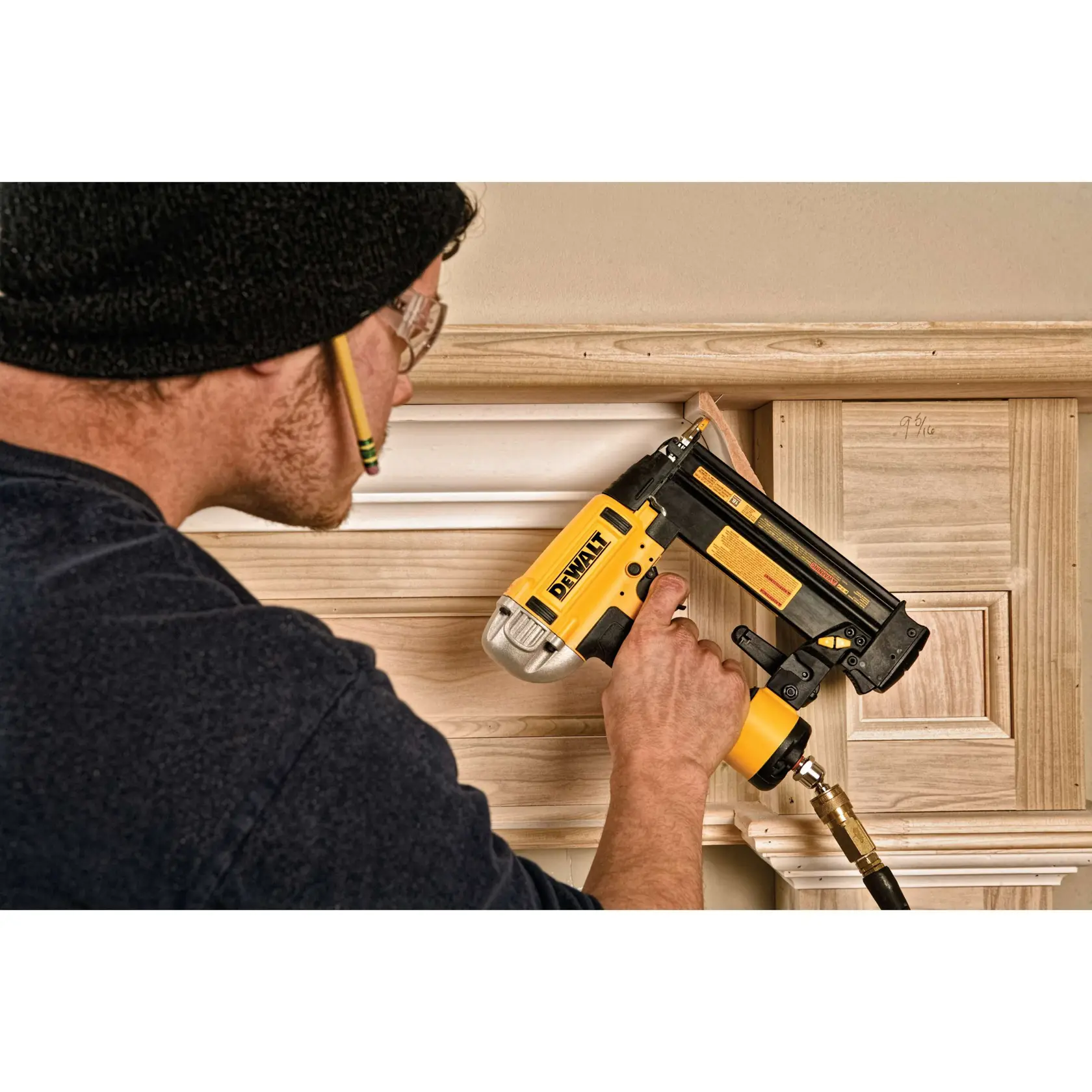 Person befestigt eine Zierleiste mit einem DEWALT Nagelgerät an Holzpaneelen.