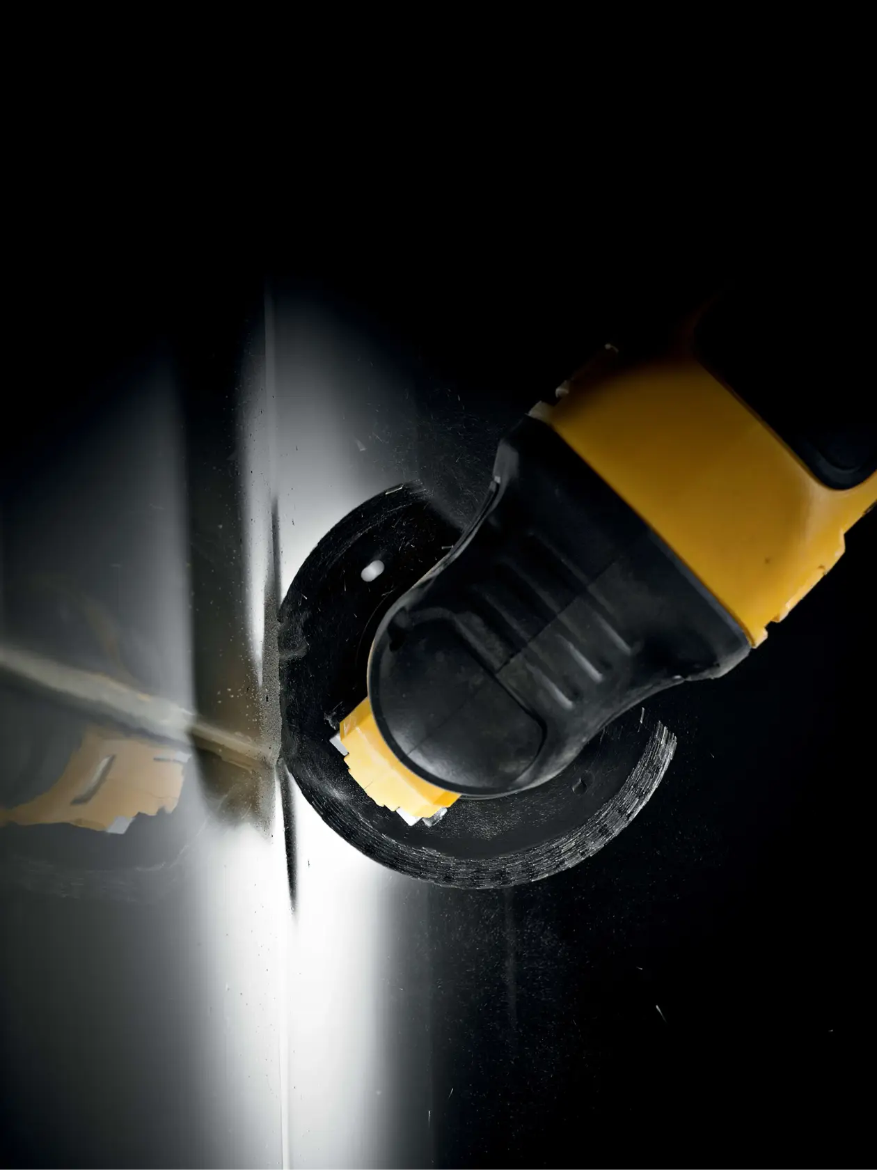 DEWALT Werkzeug mit Sägeblatt schneidet Metallblech, Nahaufnahme vor dunklem Hintergrund.