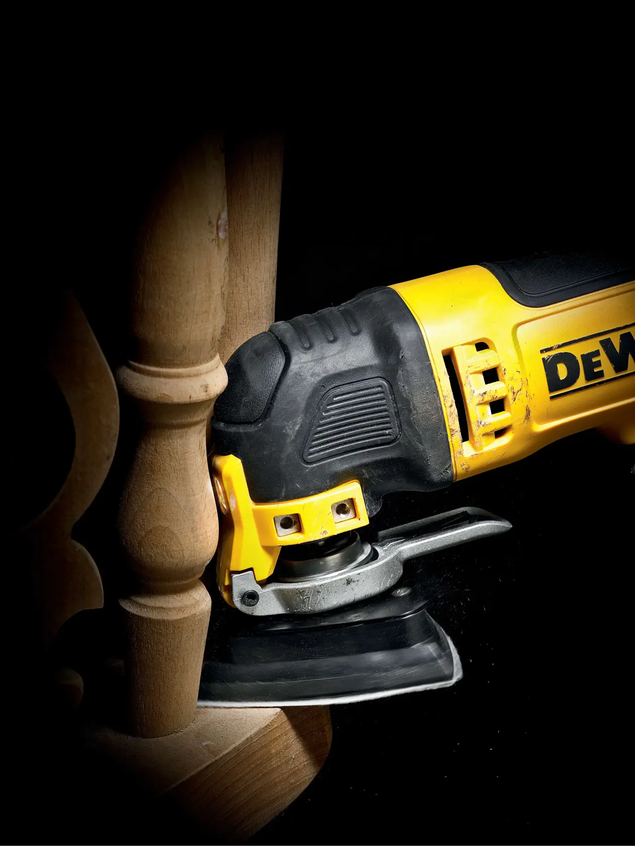 DEWALT Schleifwerkzeug im Einsatz auf Holzmöbel, Nahaufnahme mit Gerät und Holzfläche.