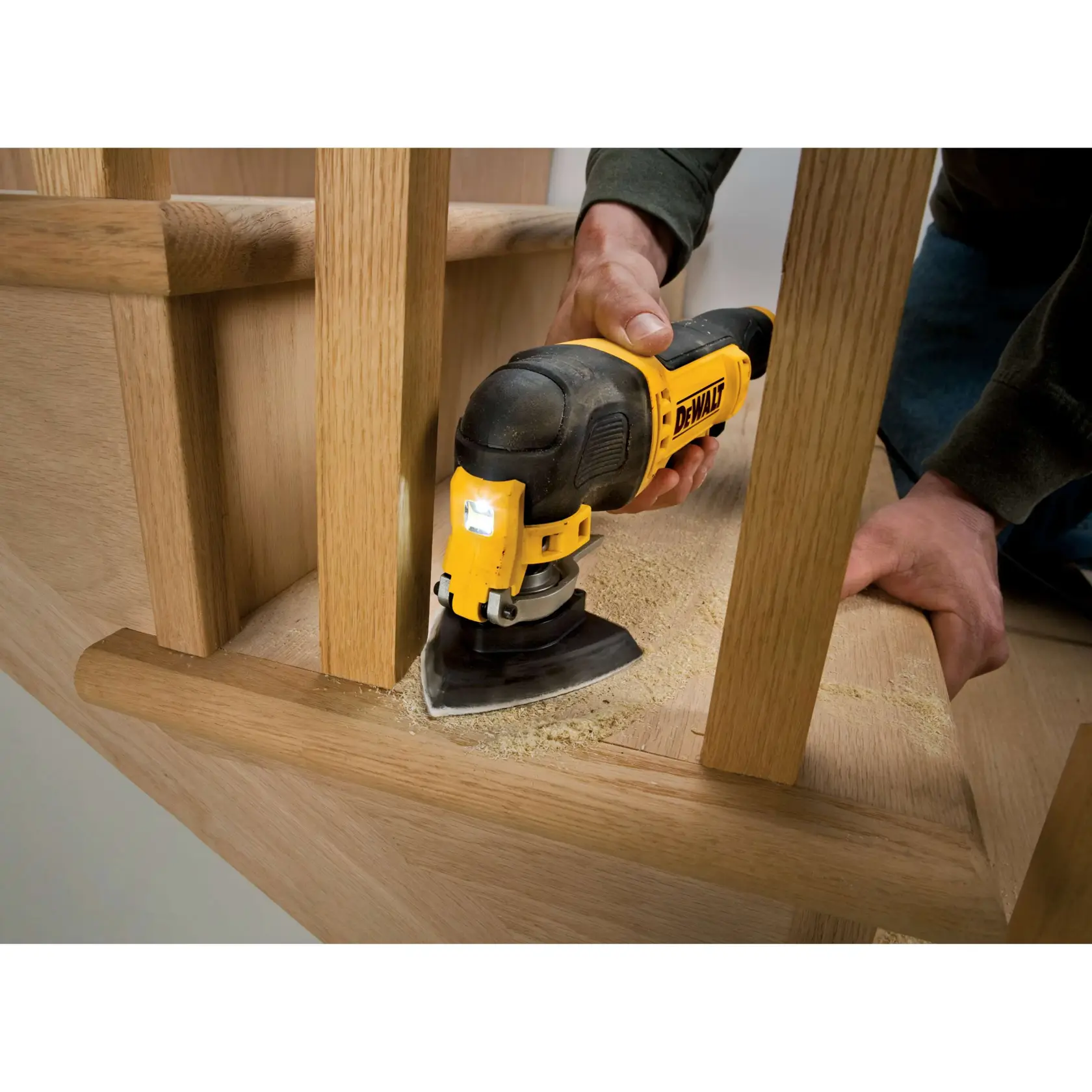 DEWALT DT3093 lijadora en uso, lijando madera cerca de barandillas. Polvo visible en la superficie.