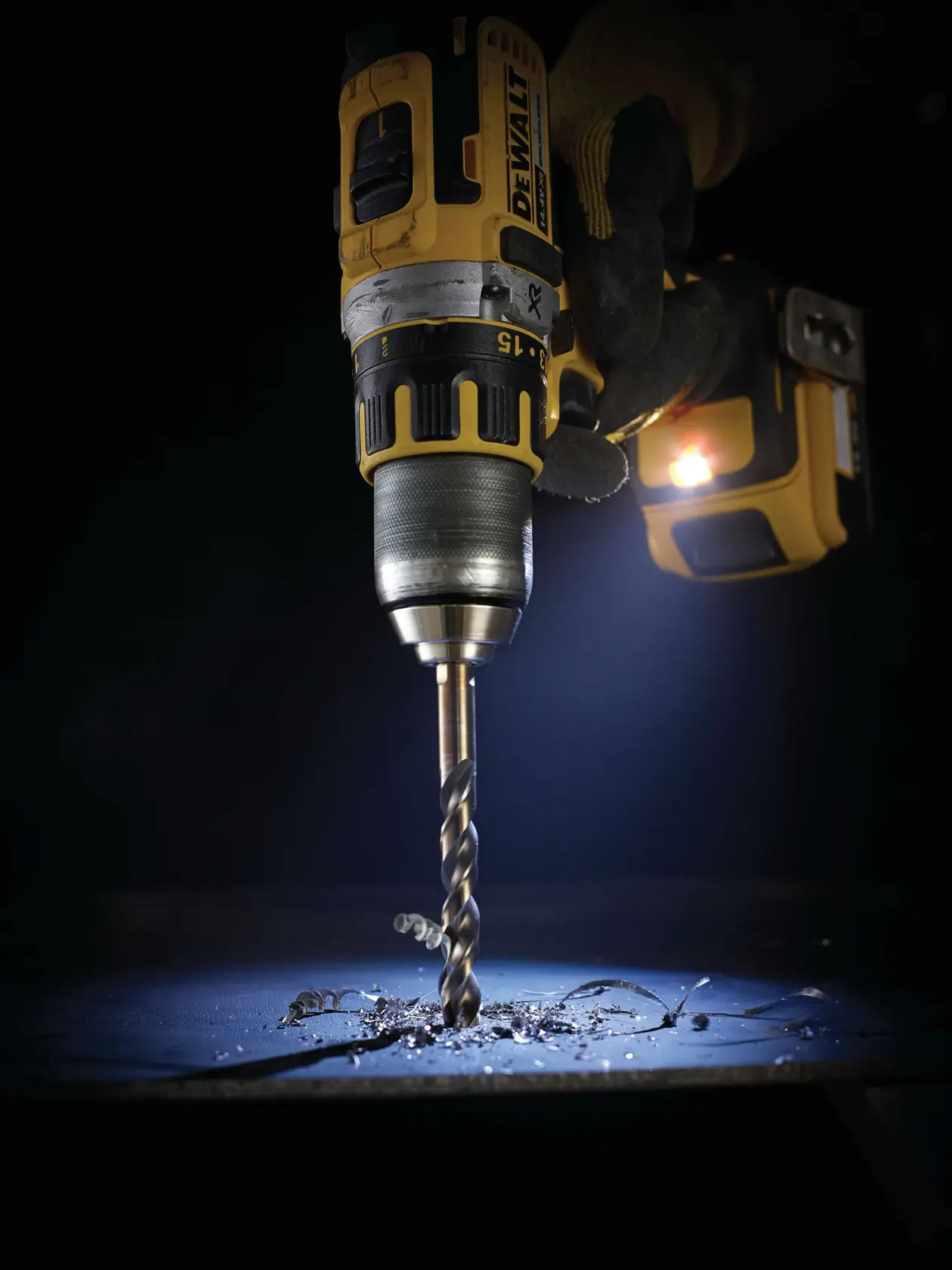 DEWALT-Bohrmaschine mit DT5067-Bohrer bohrt Metall, Späne und eingebautes Licht sind sichtbar.