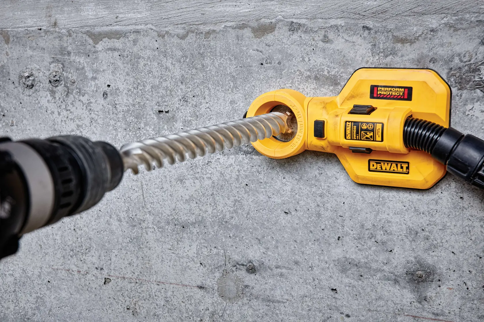 Herramienta DEWALT con broca y extracción de polvo usada en pared de hormigón.