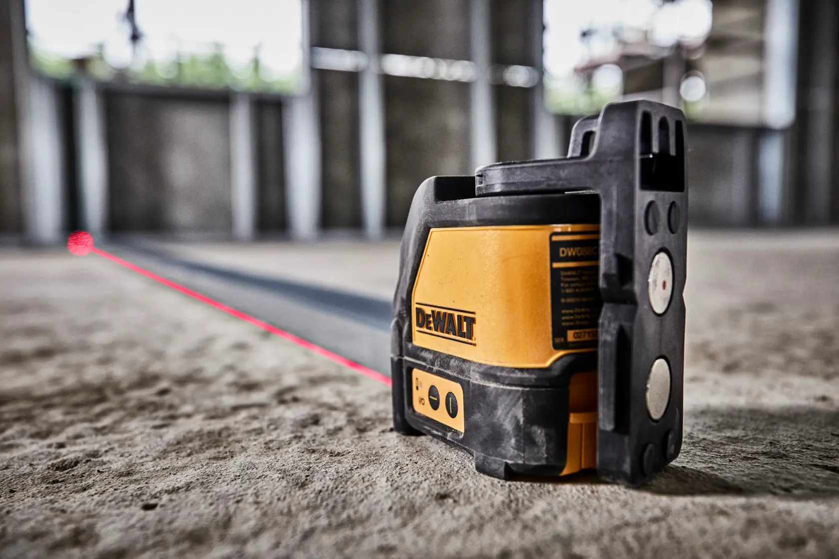 DEWALT DW088K Laser-Nivelliergerät projiziert eine rote Linie für präzise Ausrichtung am Bau.