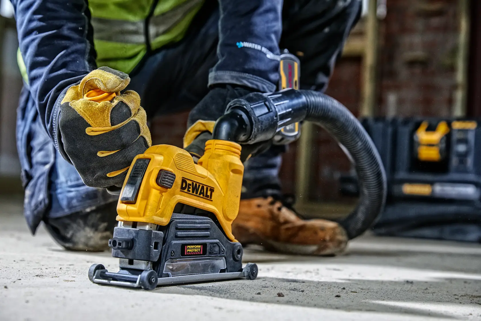 Arbeiter nutzt DEWALT DWE46225 mit Staubabsaugung auf Betonboden an einer Baustelle.