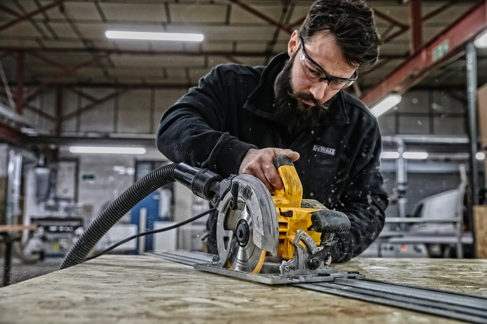 DEWALT Kreissäge im Einsatz auf Holz in Werkstatt, Bedienergesicht ist unscharf.