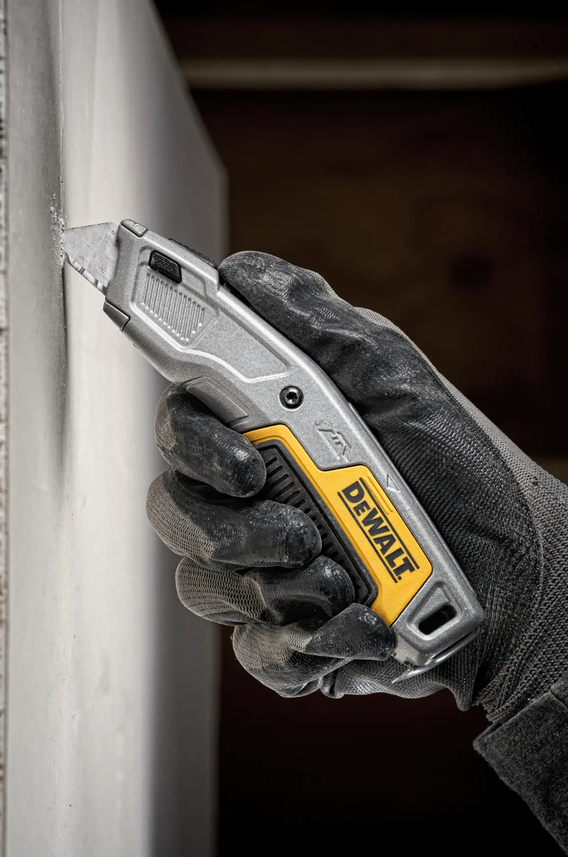 A DEWALT utility knife with a retractable blade, silver body, and yellow and black accents. The DEWALT logo is visible on the handle.