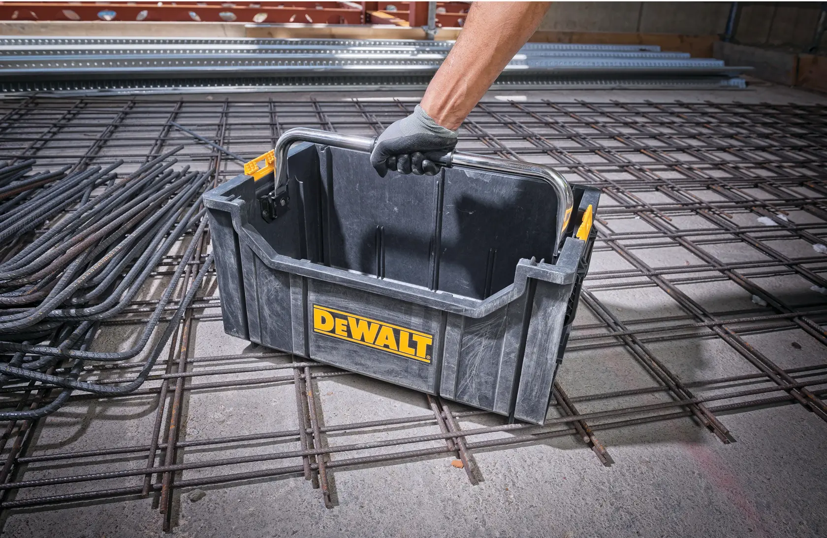 DEWALT ToughSystem 2.0 Werbegrafik mit dem Slogan 'Storage Built to Handle It' in großen, gelben Buchstaben auf einem dunklen, strukturierten Hintergrund.