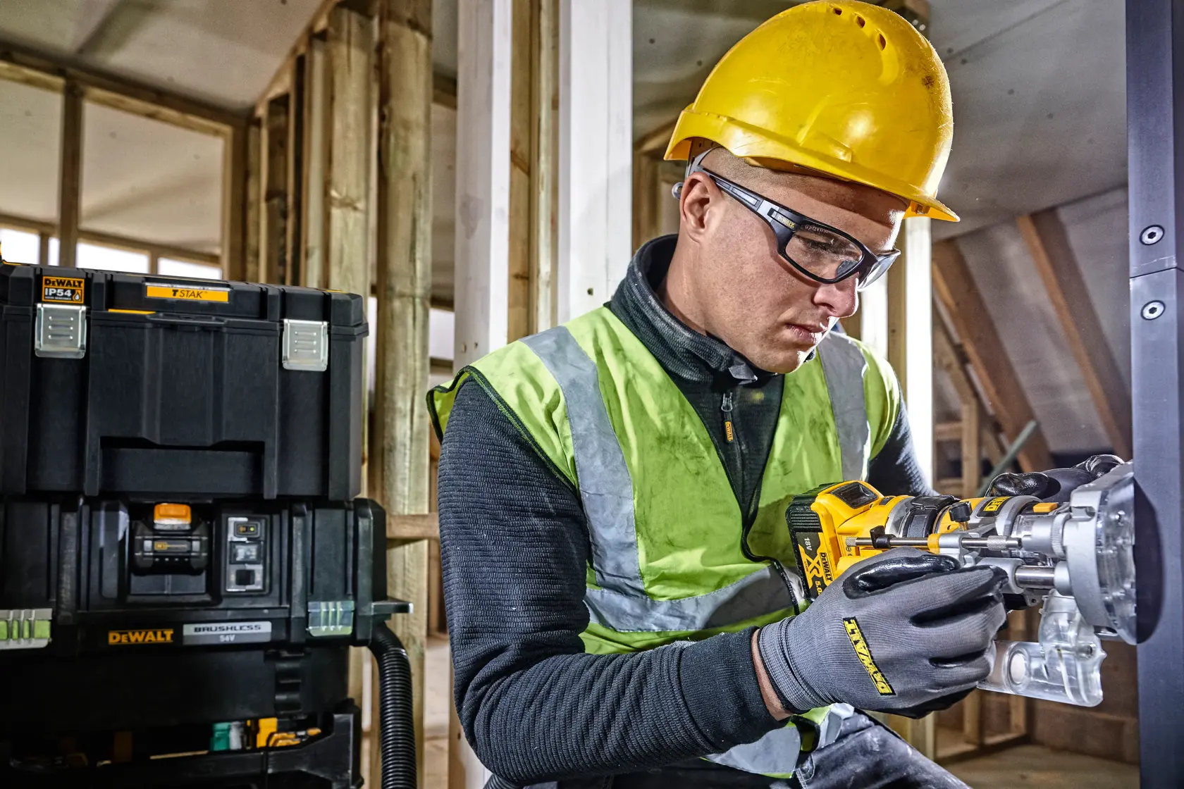 Arbeiter mit Helm nutzt DEWALT Werkzeug, DEWALT Aufbewahrungsbox im Hintergrund auf Baustelle.