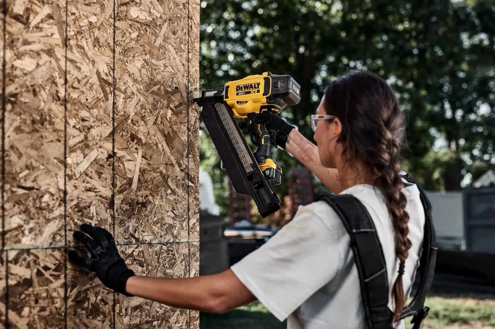 Persona usando clavadora DEWALT DZN930-XJ, DZN930 en panel de madera. Categoría: Fotografía.